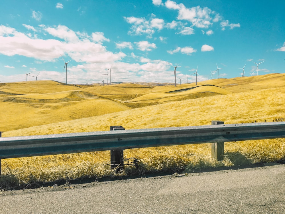 gray road barrier near wind farm