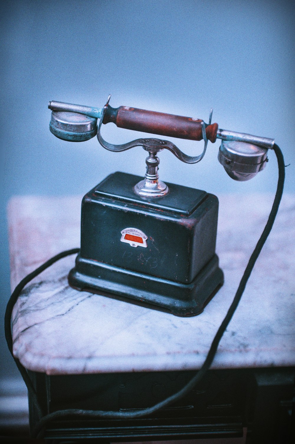 vintage blue and brown telephone on beige surface