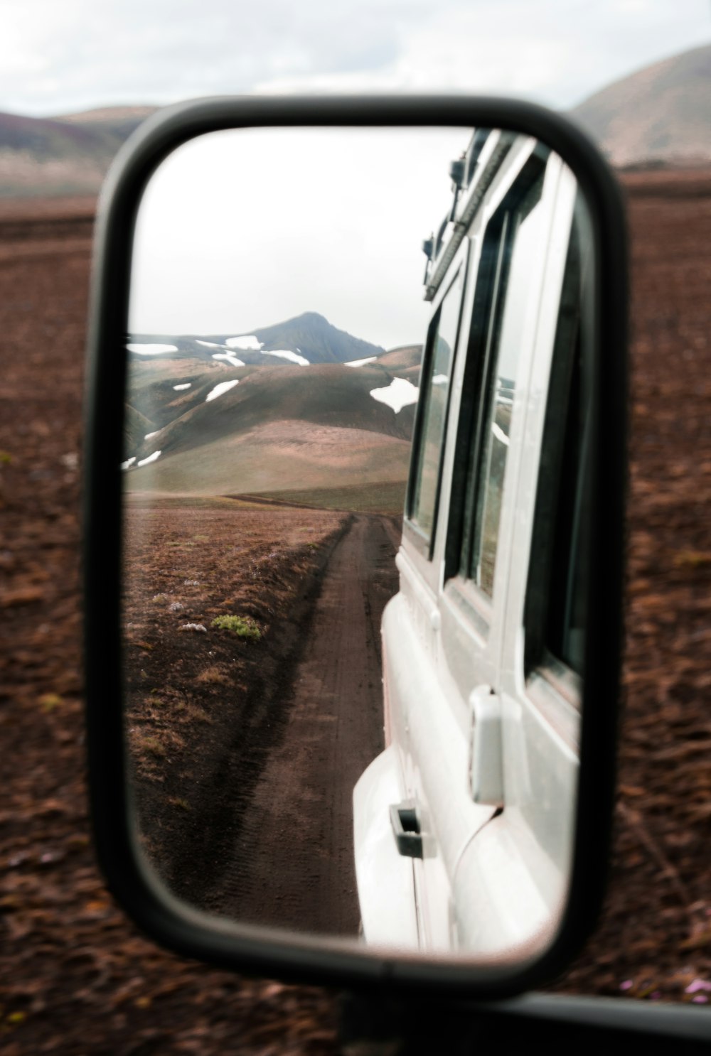 mountain range seen from vehicle wing mirror