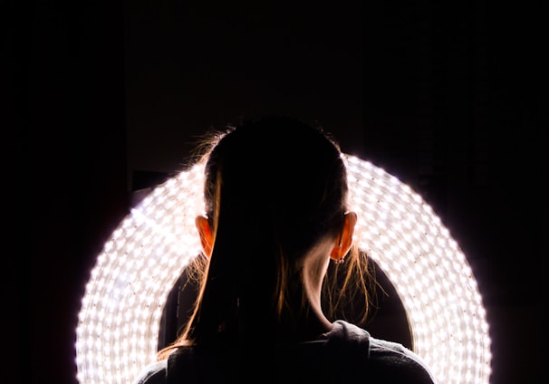 woman standing near round white vanity light