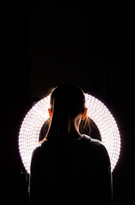 woman standing near round white vanity light