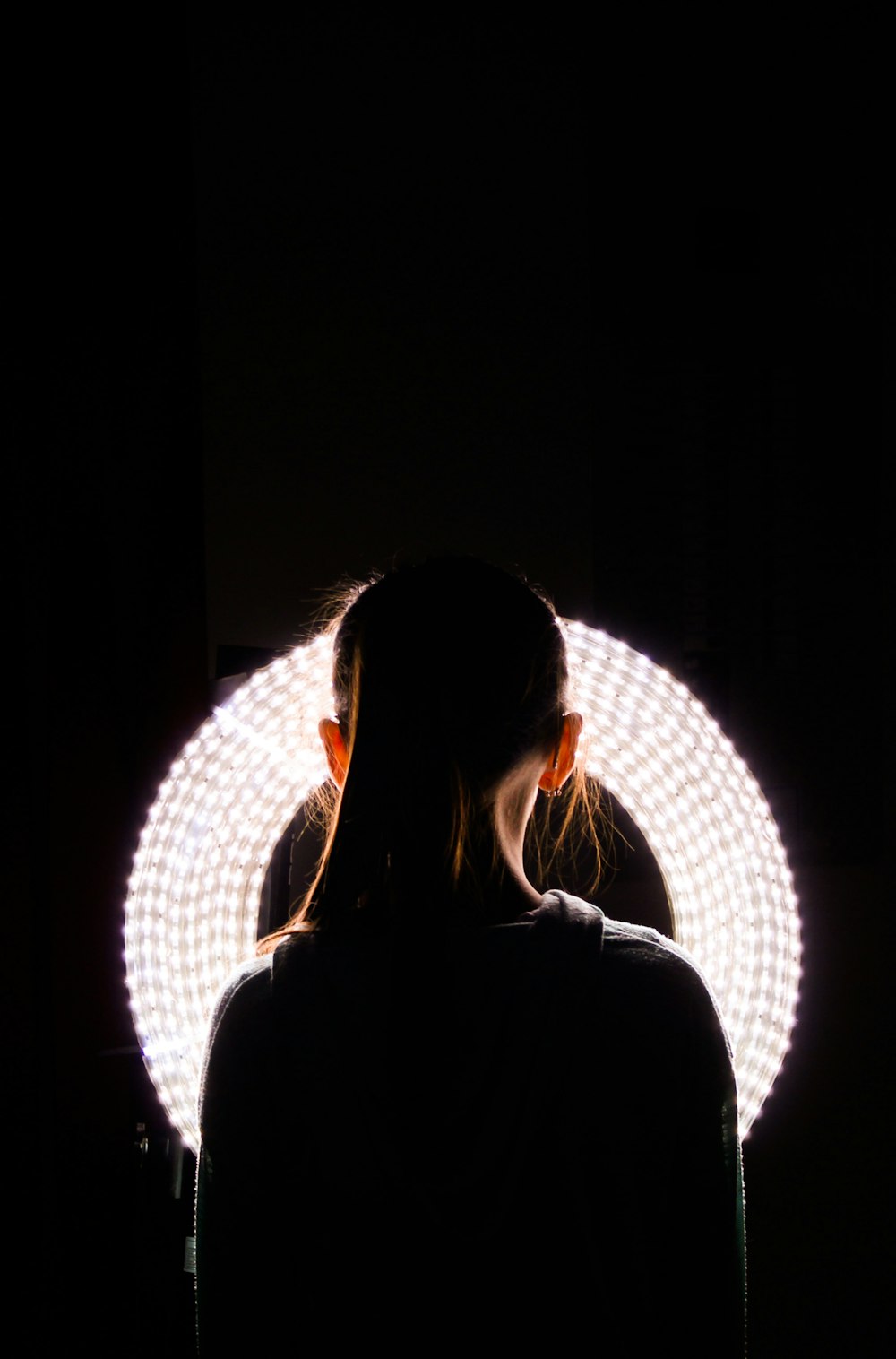 woman standing near round white vanity light