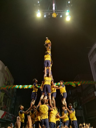 A lively class working together to build a human pyramid, smiles all around.