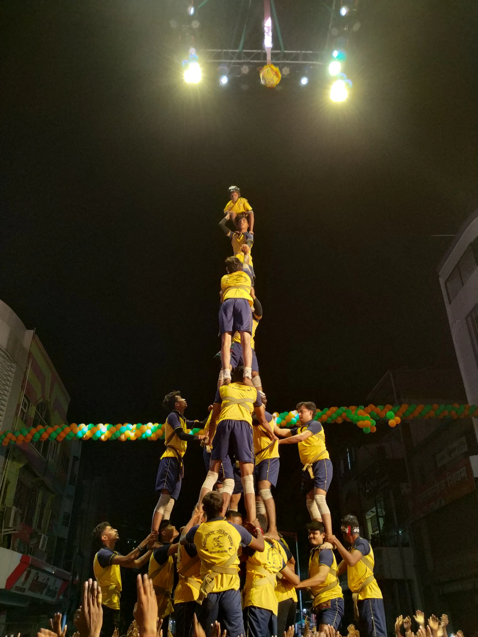 Cheerleaders from Olympus Cheer Allstar performing a high-energy pyramid formation during a sunny outdoor competition in Massy.