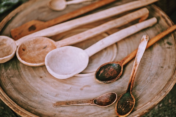 An assortment of handcrafted wooden spoons arranged artfully on a neutral background.