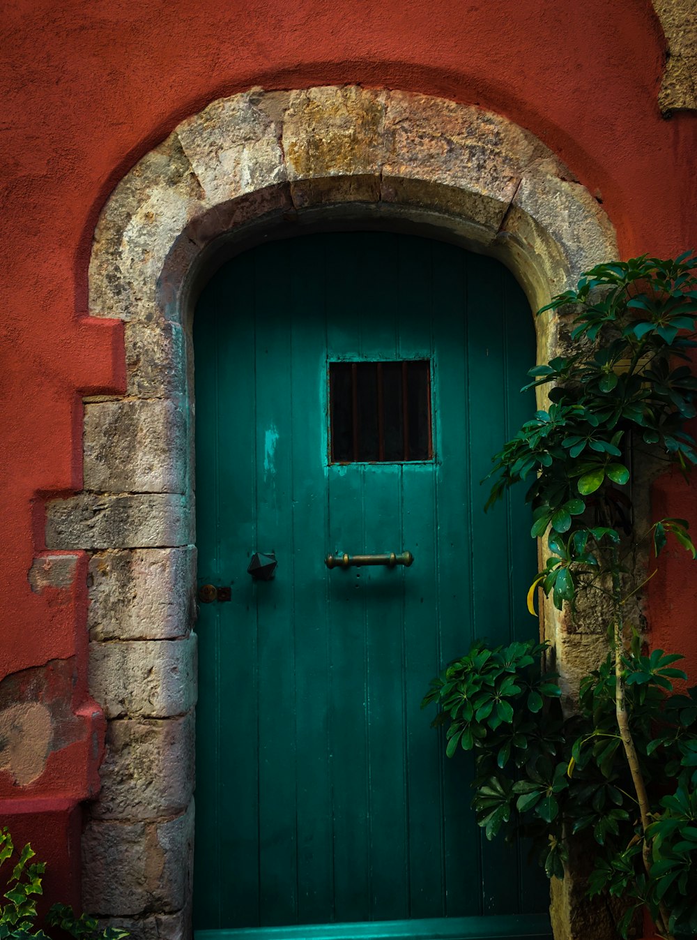 green door on a red concrete house