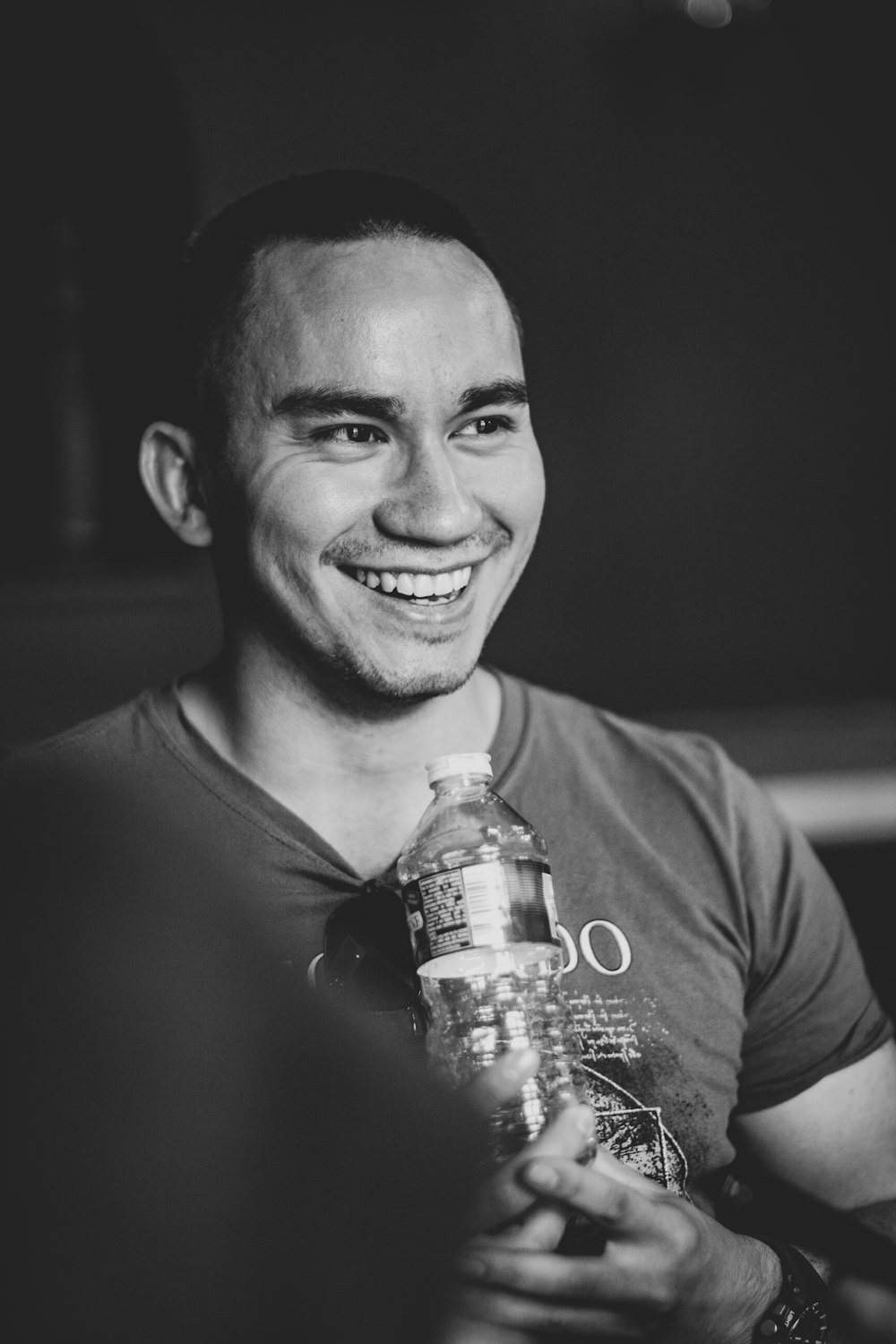 Lächelnder Mann hält klares Wasser in Flaschen