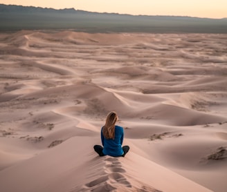woman sitting on sand field