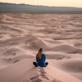 woman sitting on sand field