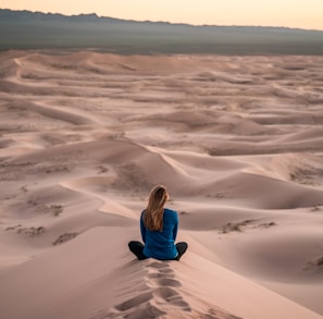 woman sitting on sand field