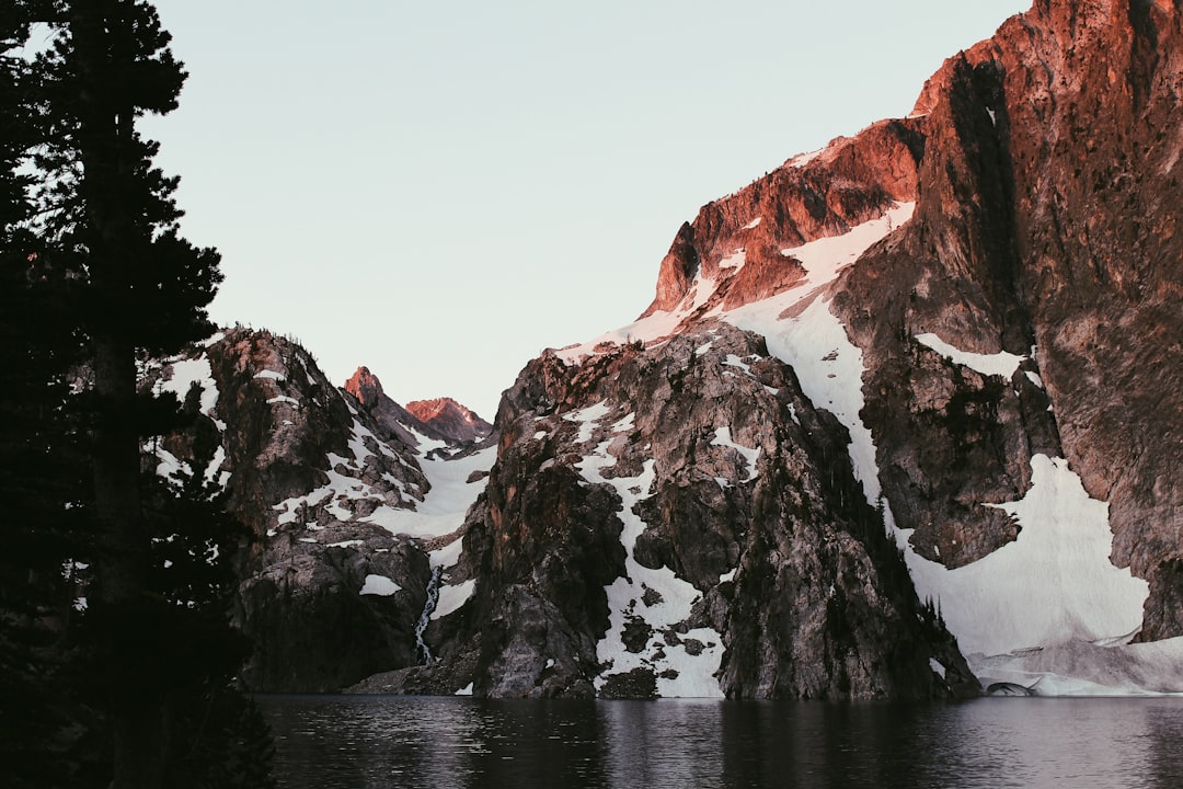 mountain covered with snow on body of water