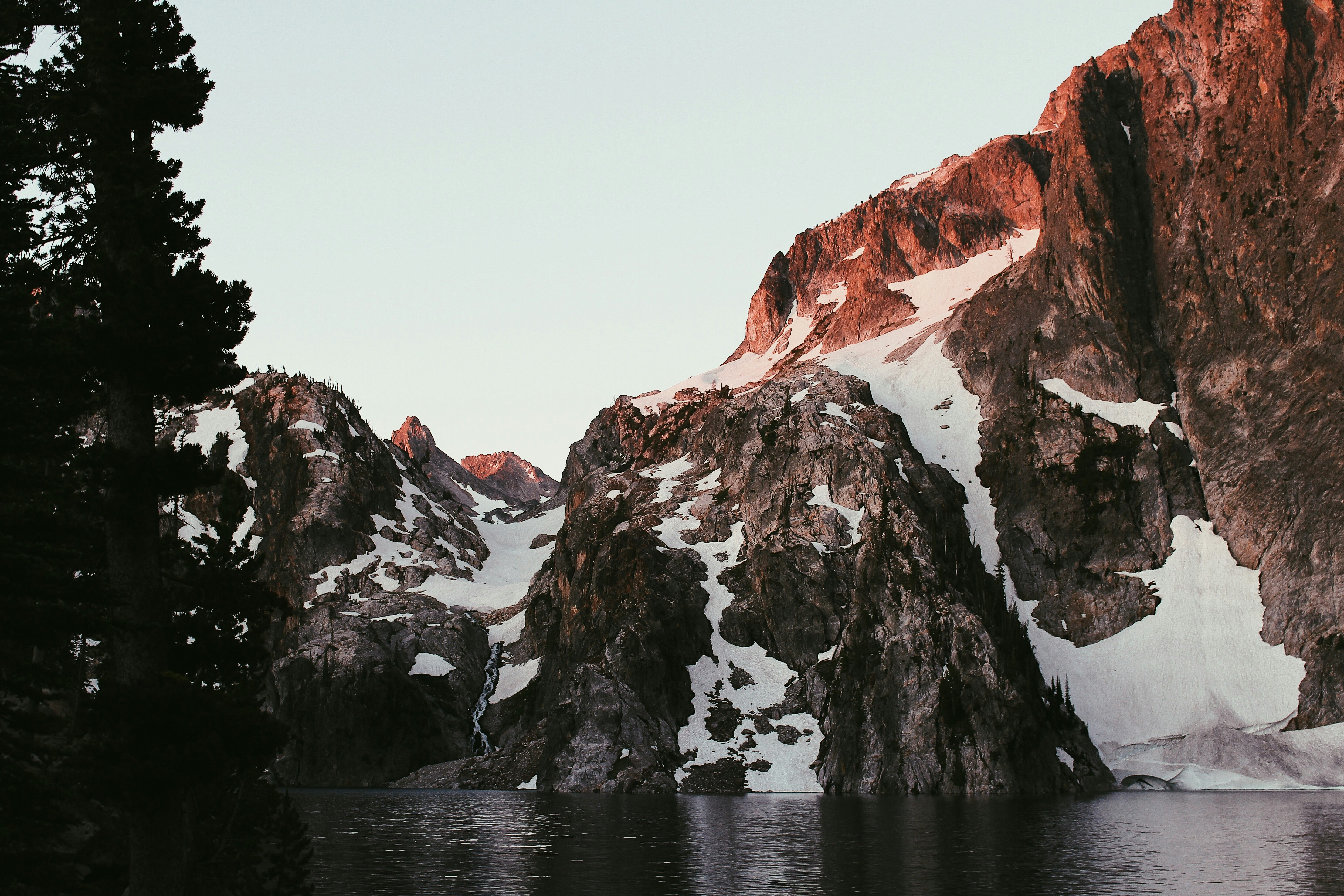 mountain covered with snow on body of water