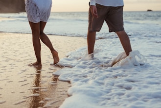 two person walking on shore