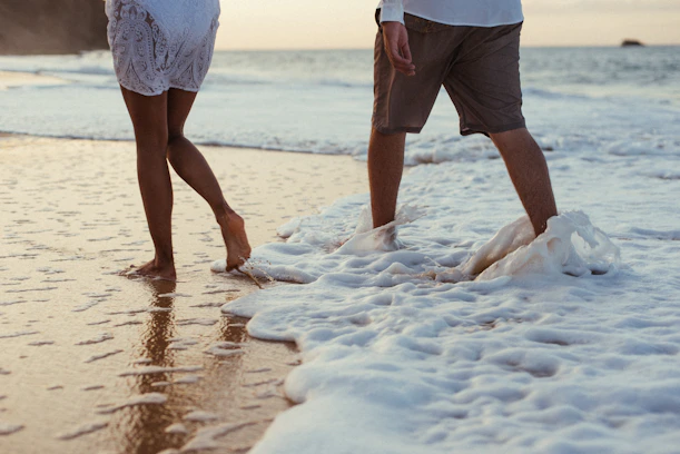 Two people walking beside the ocean representing confidence and progress