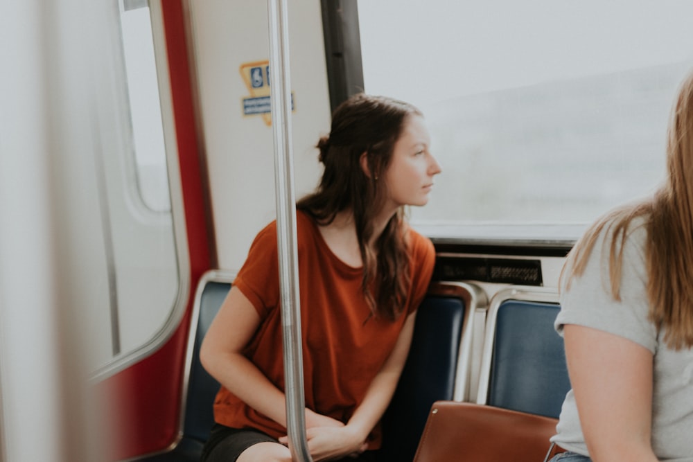 woman sitting on gang chair beside window