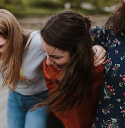 three woman holding each other and smiling while taking a photo