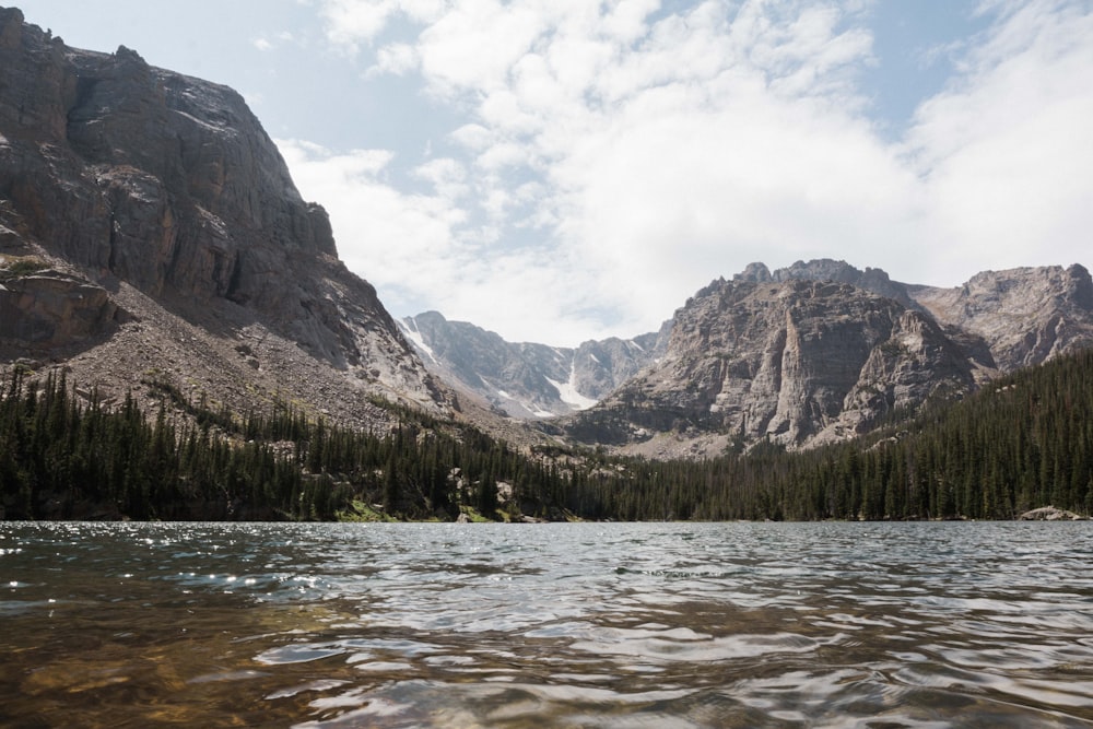 body of water near brown rocky cliff under blue sky