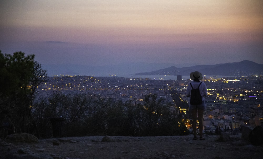 Mujer de pie en el pavimento gris con vistas a la ciudad