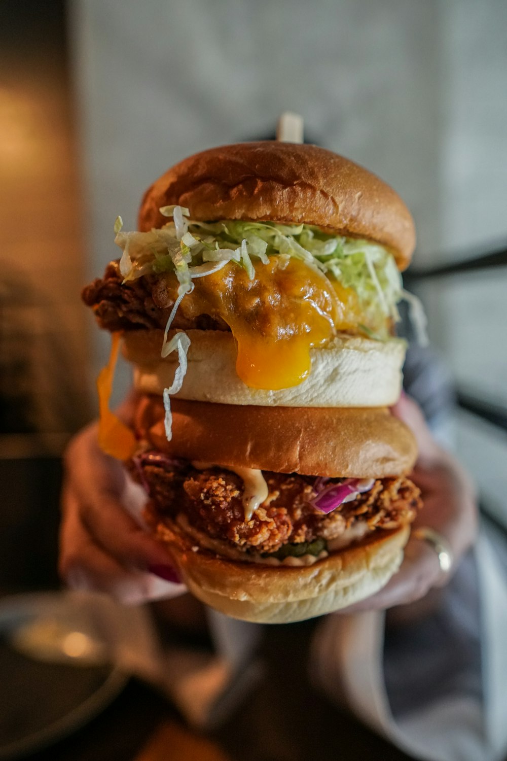 person holding burger with lettuce