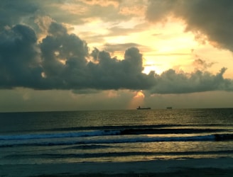 A film crew capturing a dramatic sunset scene on the Vizag coastline.
