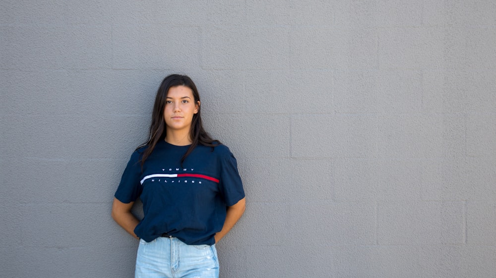 woman standing while leaning on wall