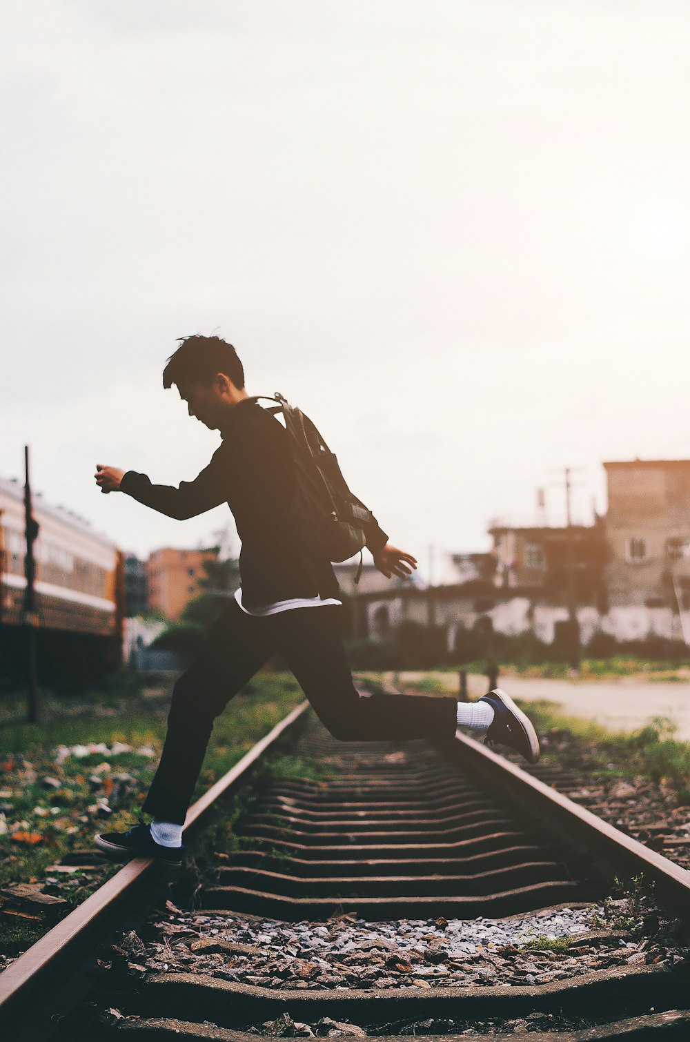 man crossing train track