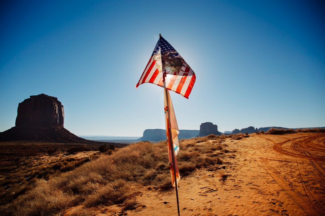 USA flag waving over brown sand