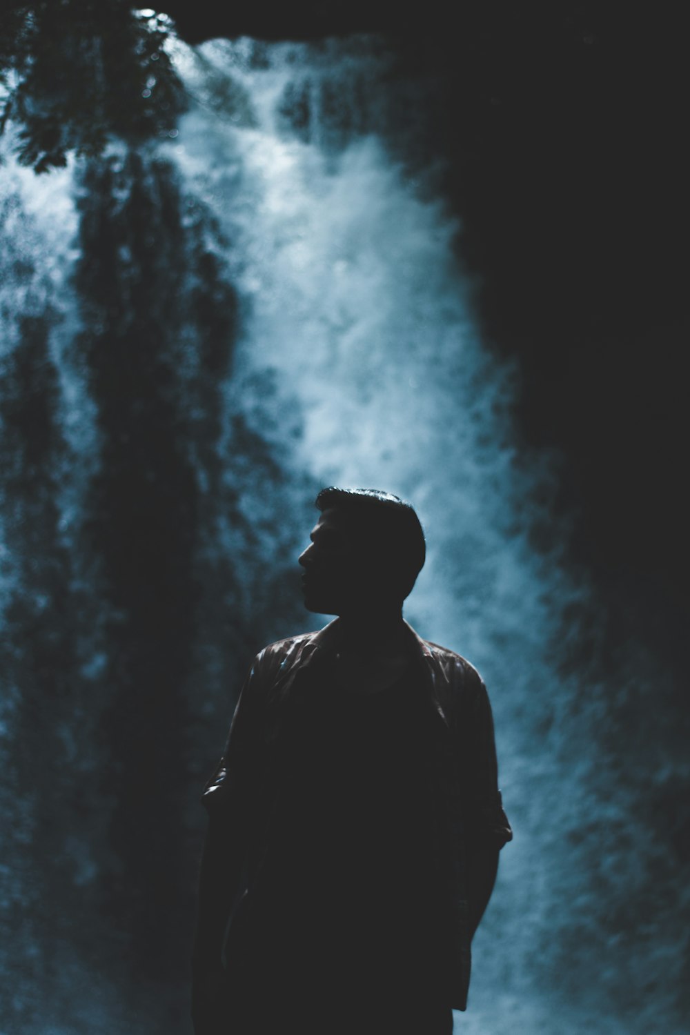 silhouette of man with rushing waterfalls on background