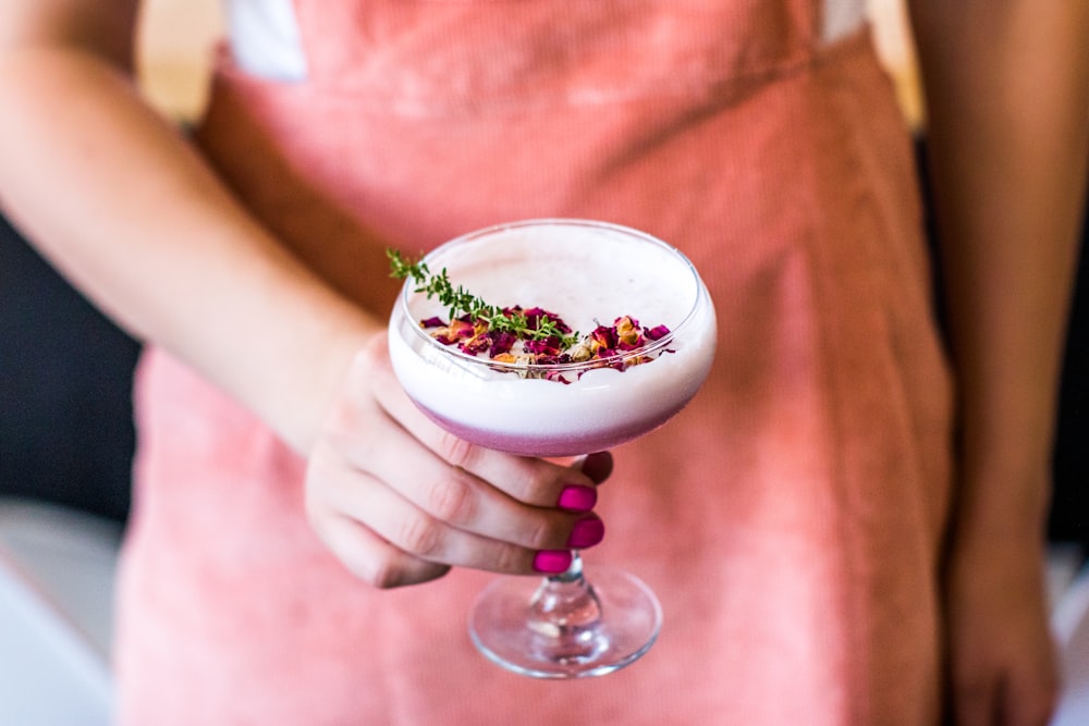 person holding wine glass filled with beverage