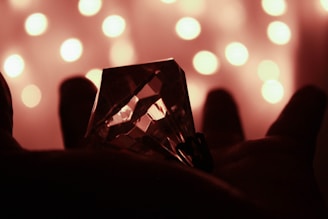 Close-up of hands holding a glowing crystal with soft natural light.