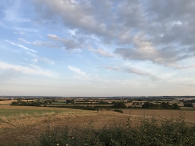 Spacious rural land with green pastures and blue sky.
