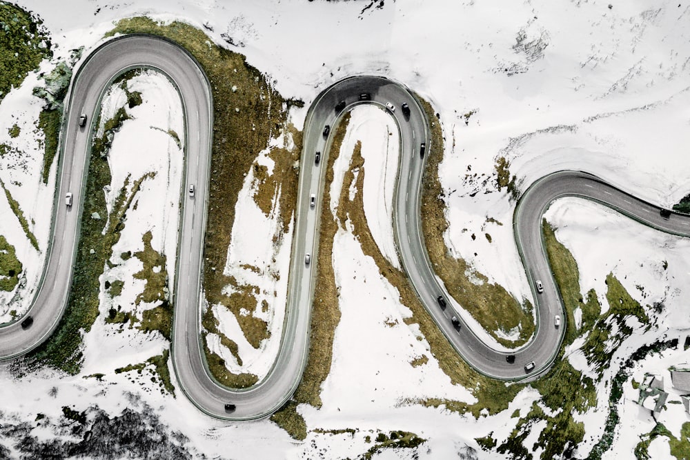 Photographie aérienne de véhicules sur une route entourée de neige pendant la journée