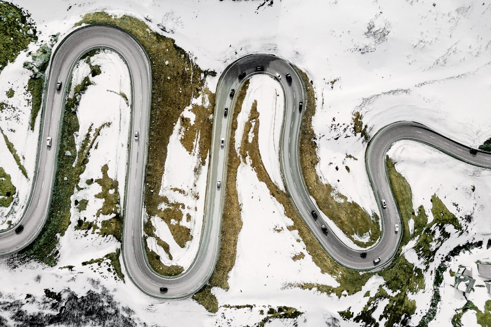 fotografia aérea de veículos na estrada cercados de neve durante o dia