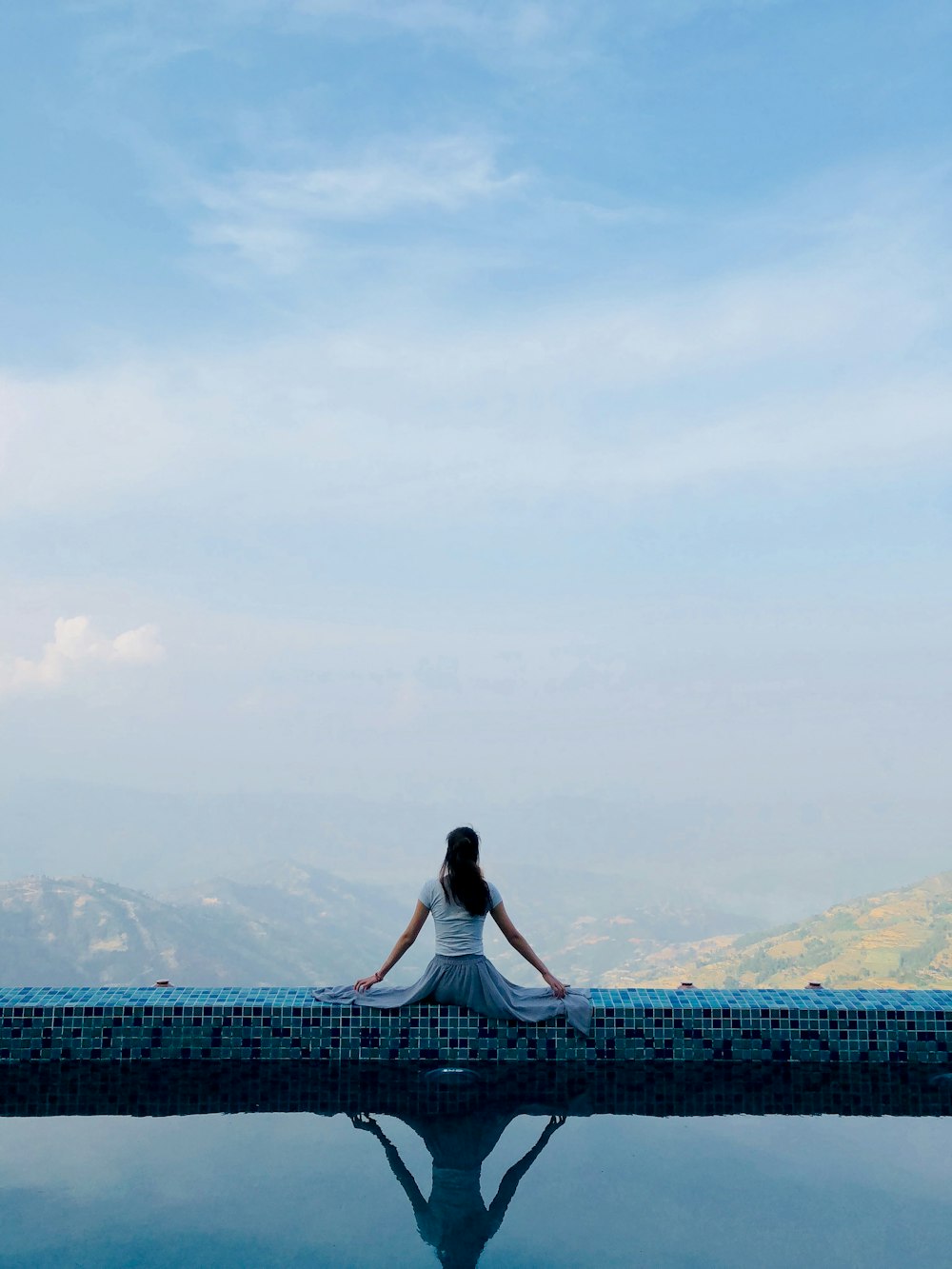 woman sitting on pool gutter