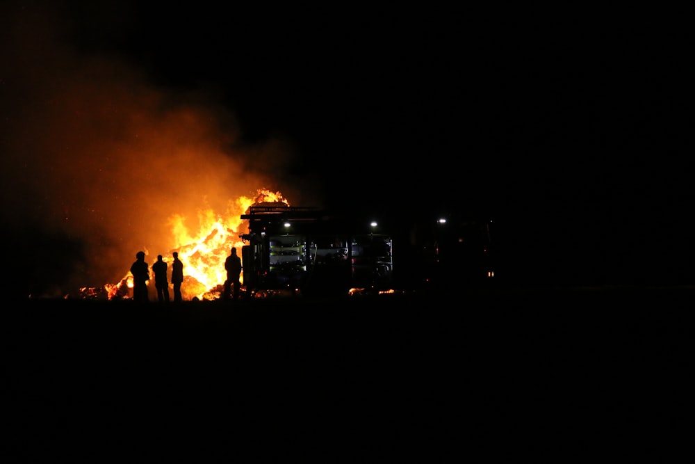 a group of people standing in front of a fire