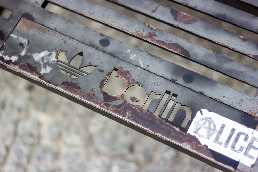 a close up of a metal bench with a sign on it