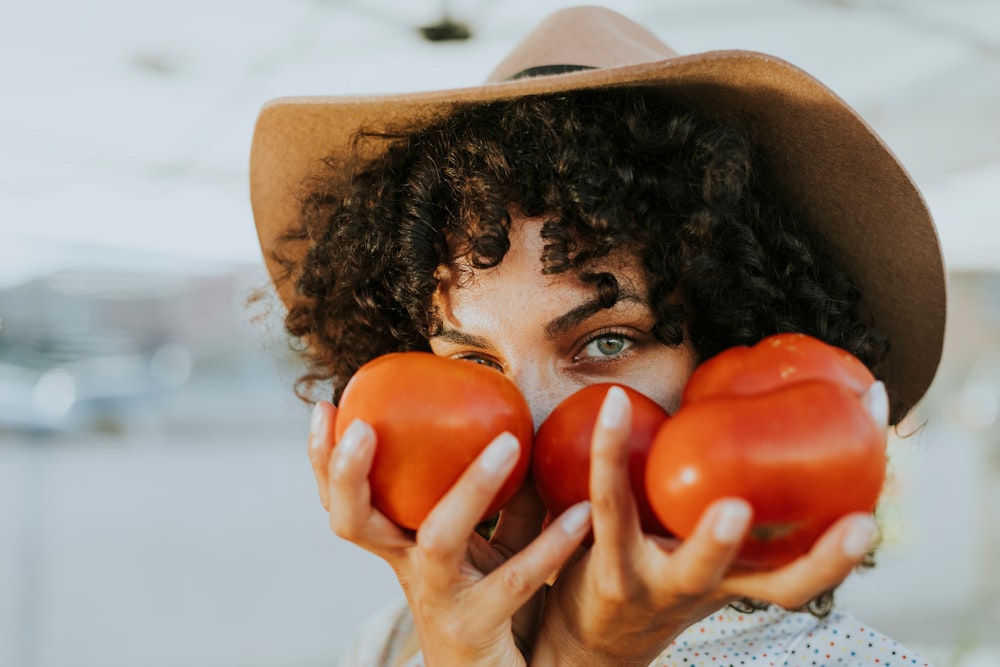 person holding red tomatoes