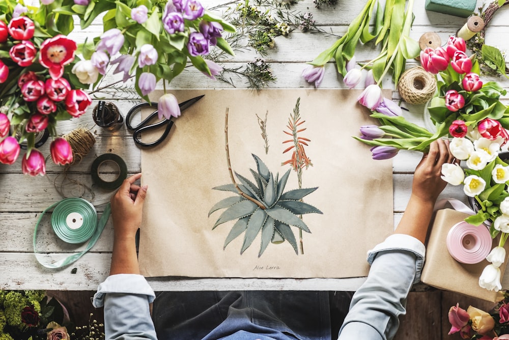 person in gray top painting flowers