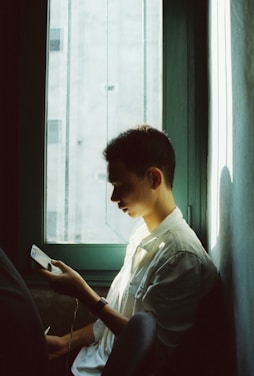 A warm, comforting scene of a person using the myangel app on their phone while smiling, with soft natural light.
