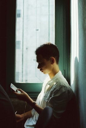 A serene person holding a phone displaying the the order app interface, surrounded by soft natural light.