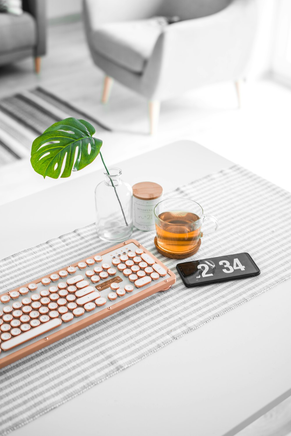 brown computer keyboard beside glass mug