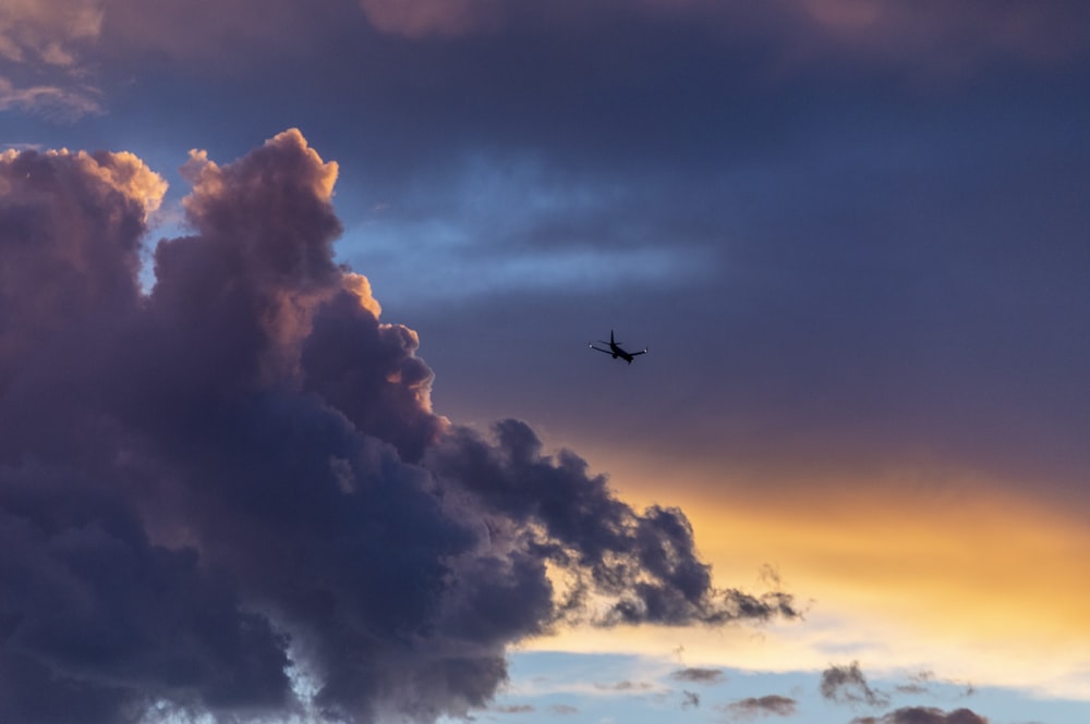 low-angle photography of plane near clouds