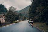 Cyclists racing on a winding mountain trail surrounded by lush greenery