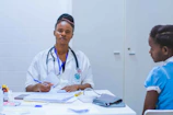 doctor sitting at the table in front of girl