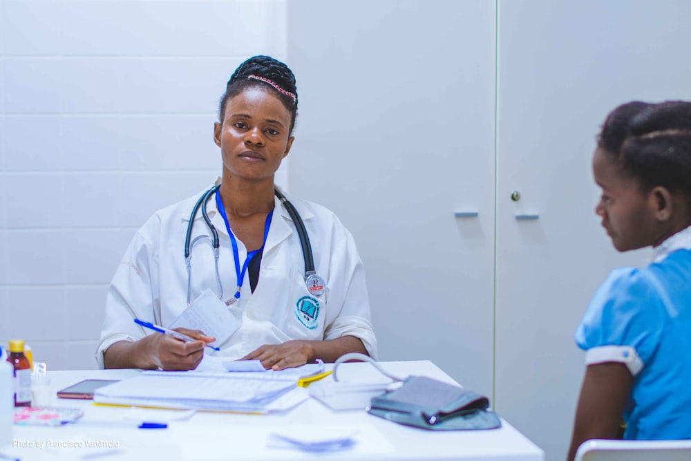 médico sentado en la mesa frente a la chica