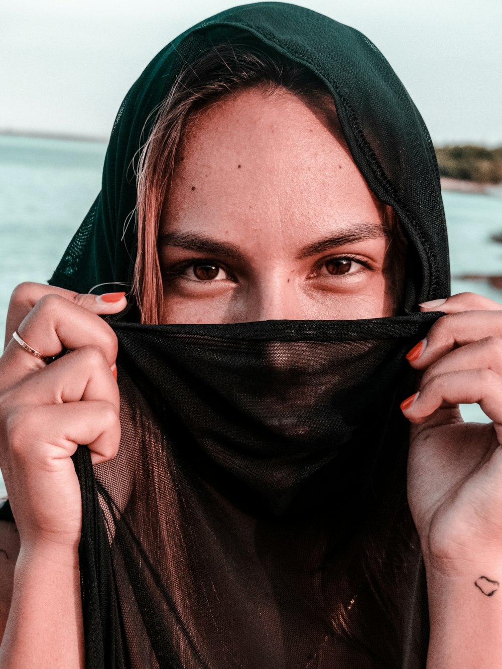 woman covering mouth with black shirt