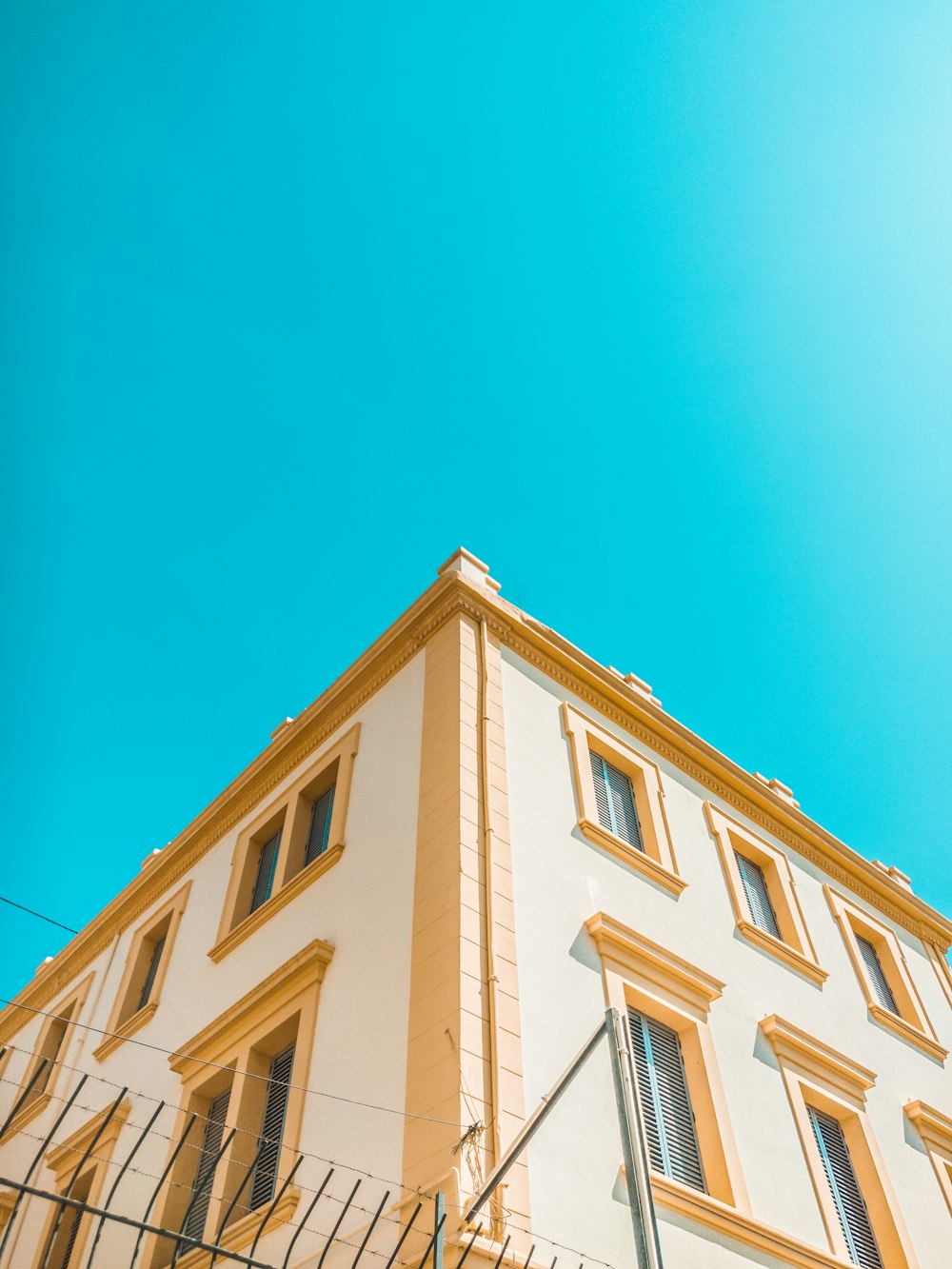 worm's-eye view photography of yellow and brown concrete house under clear sky