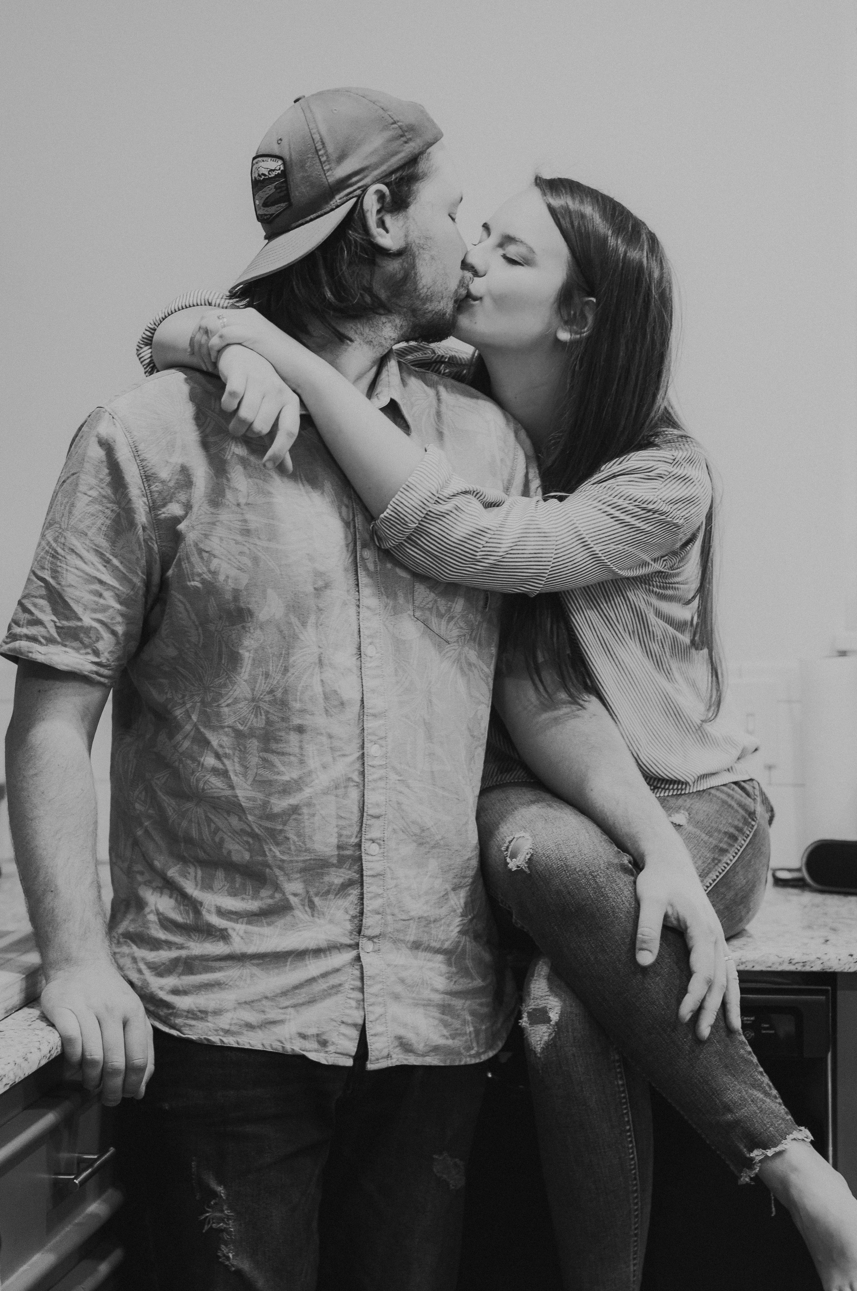 grayscale photo of man and woman kissing each other