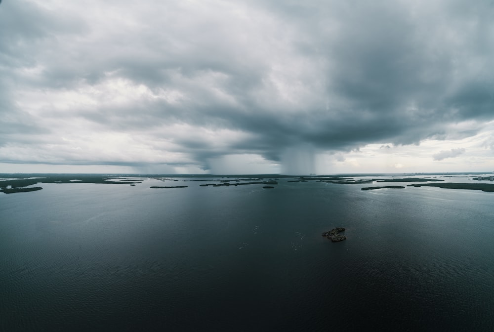 Plan d’eau calme sous des nuages blancs