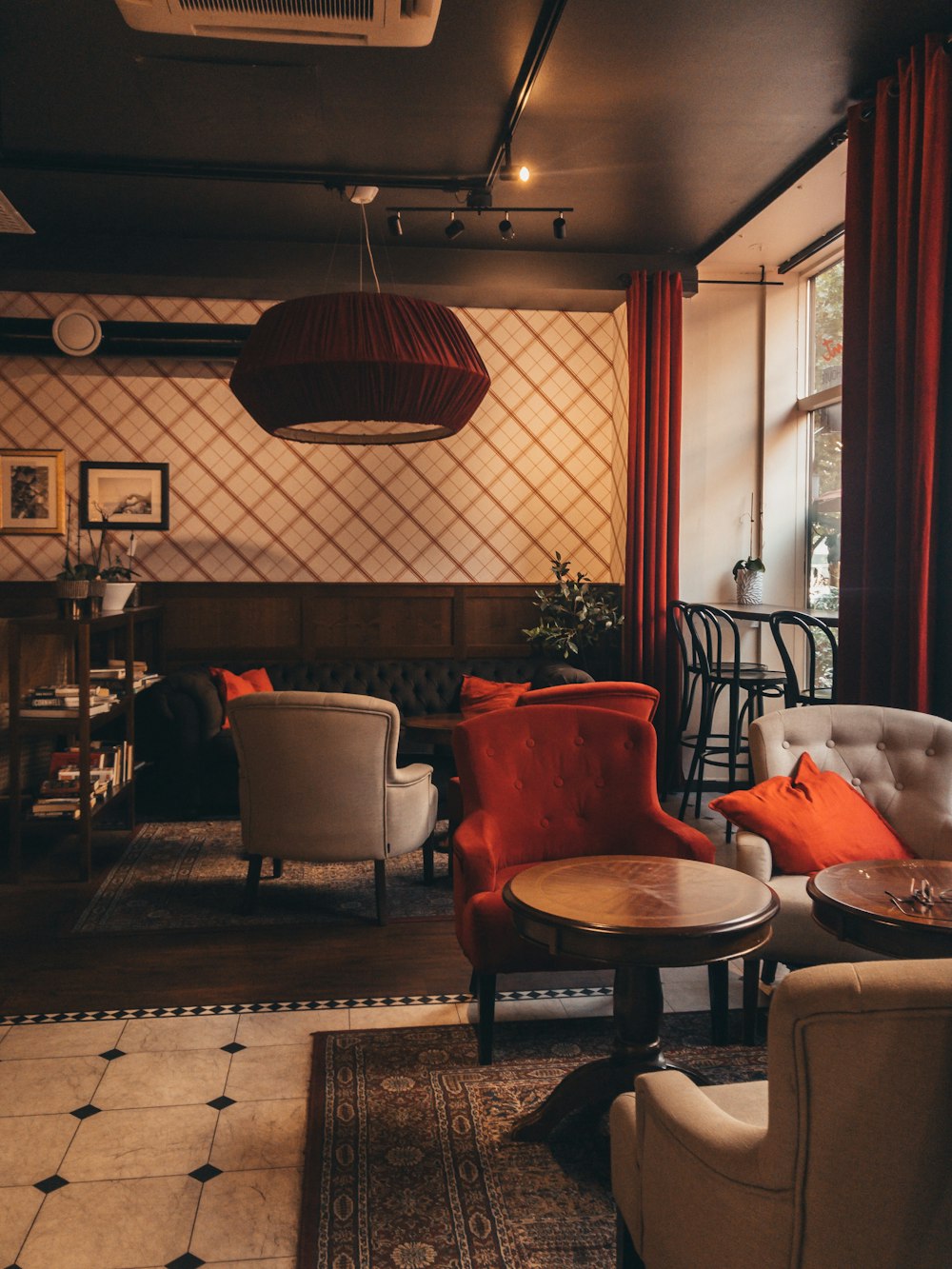 two tufted red and gray sofa chairs in front of tables